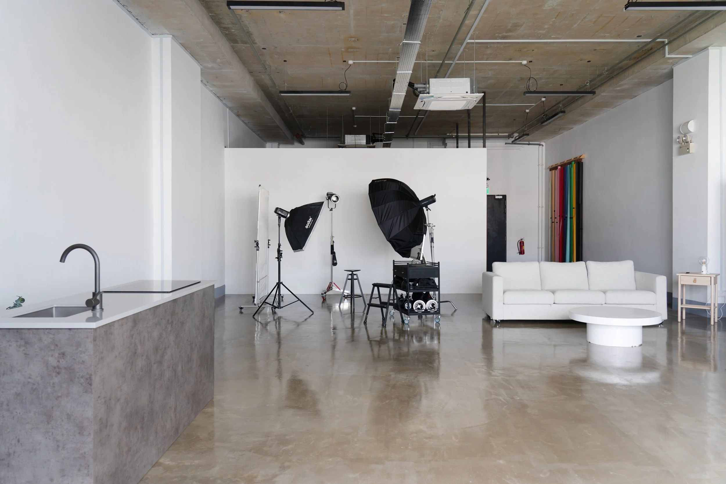 The studio with softboxes, octabox and equipment cart set against the white wall