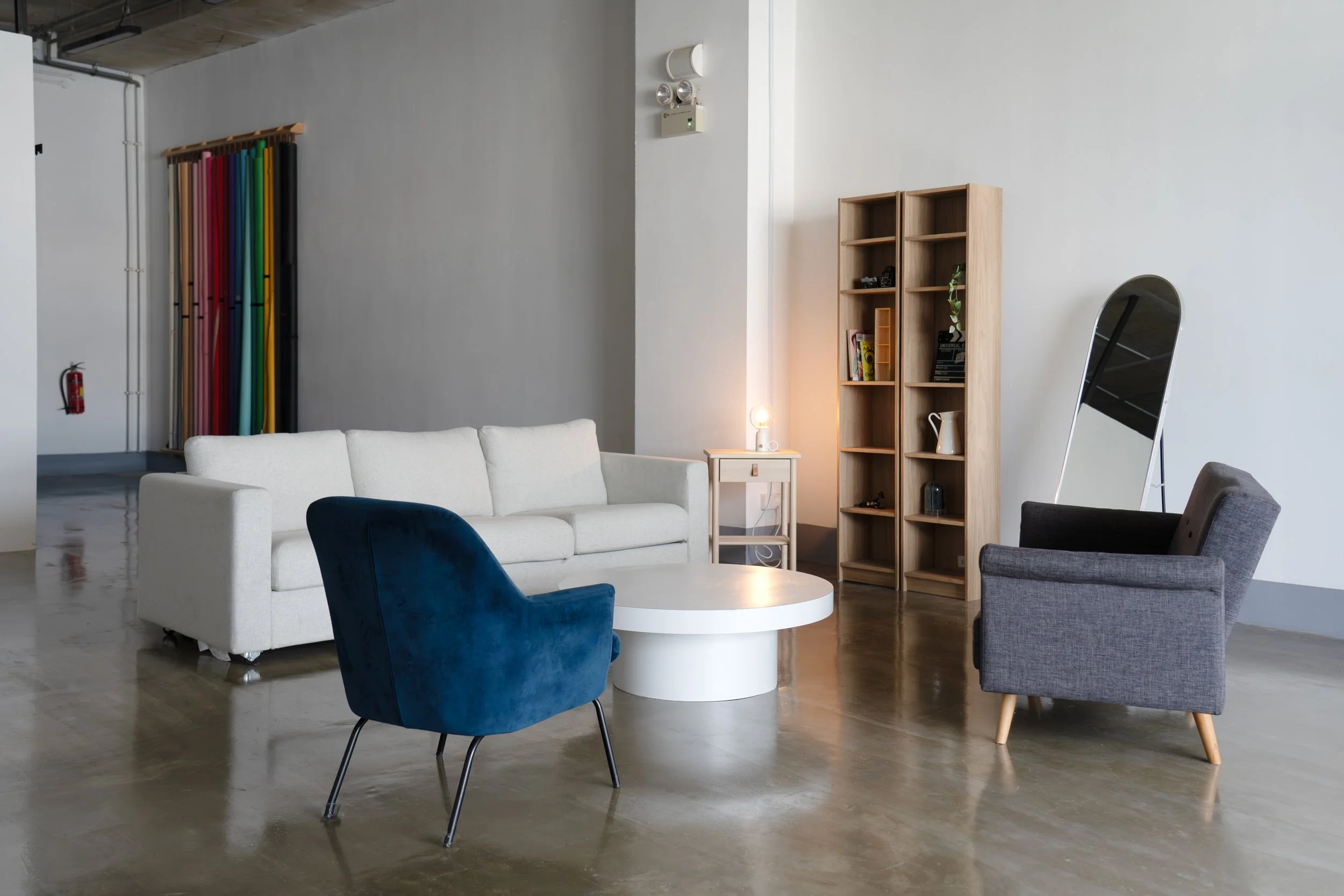 The lounge corner — white sofa, blue velvet armchair and coffee table